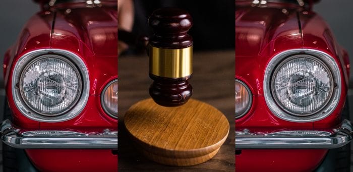 Dieses Foto zeigt einen Auktionshammer und einen Oldtimer.