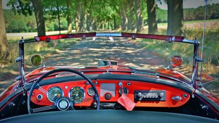 Dieses Foto zeigt ein Oldtimer-Cabrio bei einer gemütlichen Tour über ruhige Nebenstraßen.