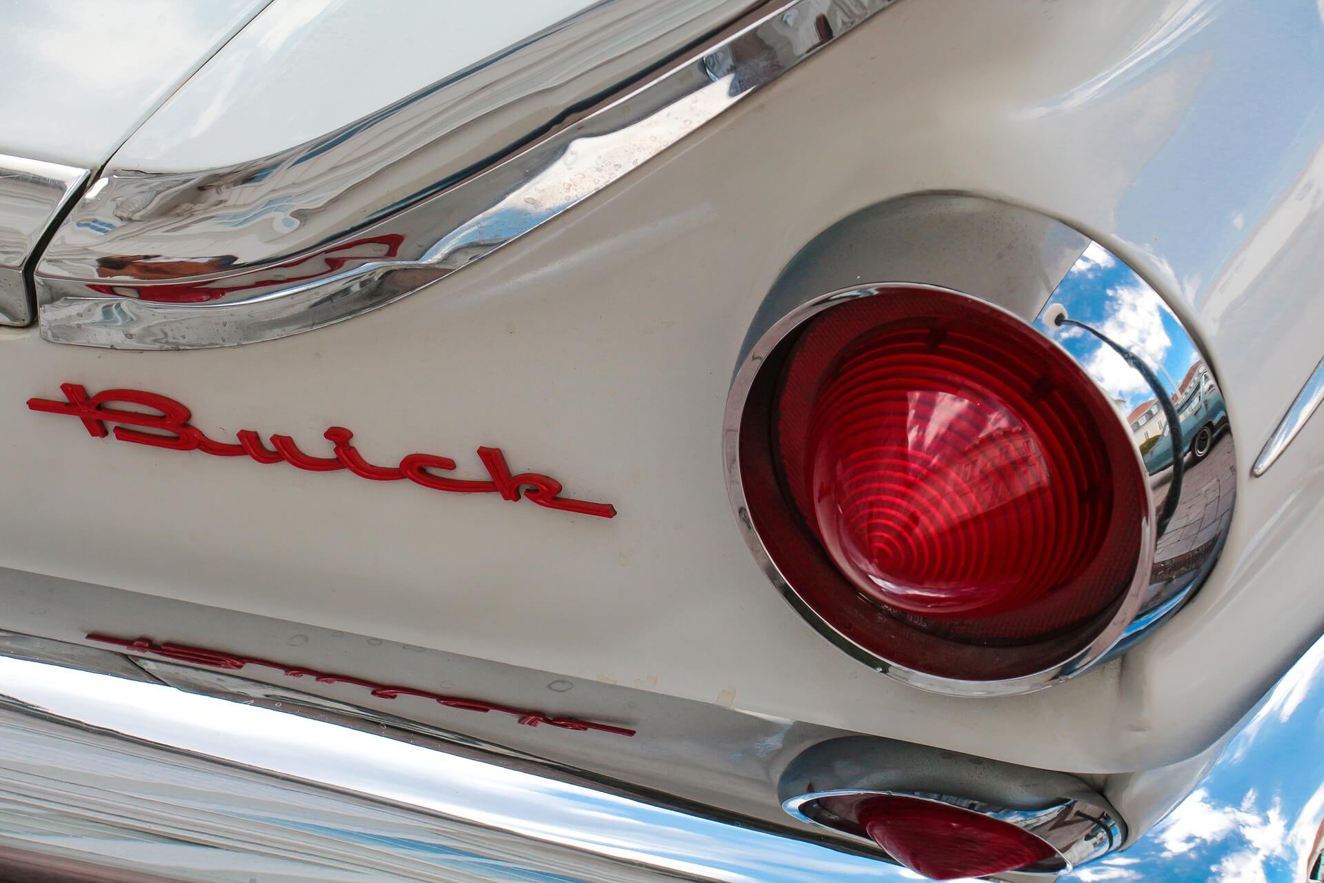 Rückleuchte und Markenschriftzug eines weißen Buick Oldtimers