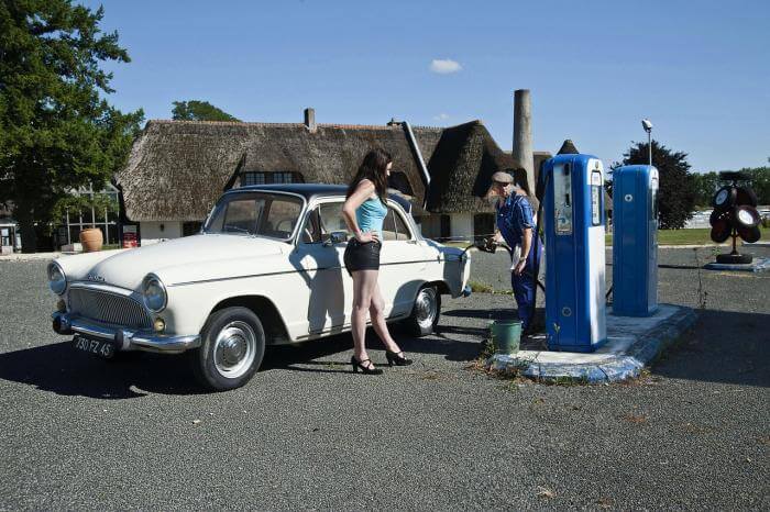 weißer Simca Aronde Oldtimer beim Betanken an der Tankstelle